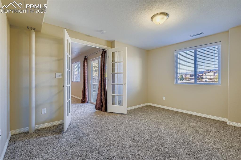 Image 34 of 49: Bedroom #5 in Basement with French Doors and mountain views