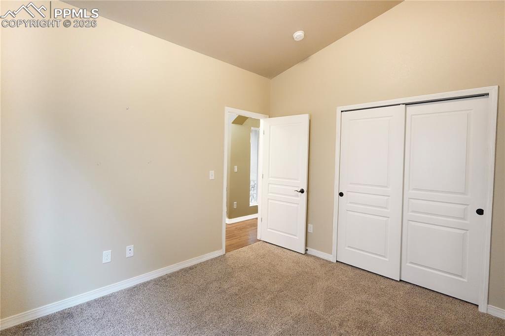 Image 17 of 44: Unfurnished bedroom with light carpet, vaulted ceiling, and a closet