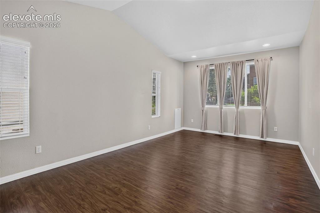 Image 18 of 50: Vaulted ceiling with recessed lighting, wood-finish flooring, and multiple