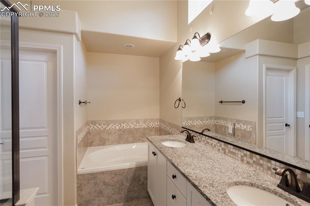 Image 23 of 44: Bathroom featuring double vanity and a bath