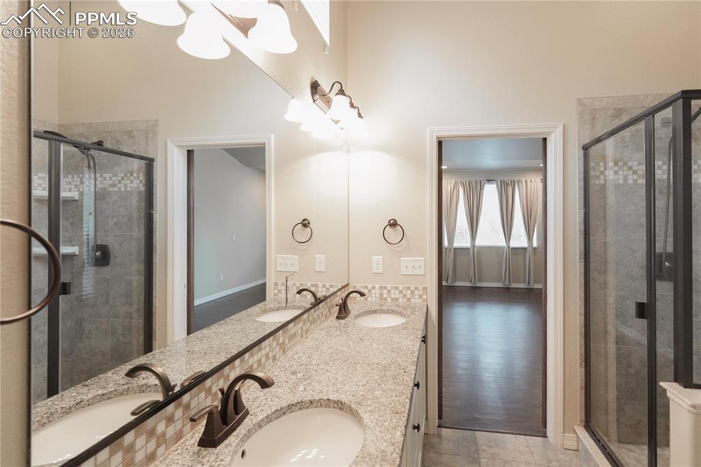 Image 24 of 44: Full bath featuring double vanity and a shower stall