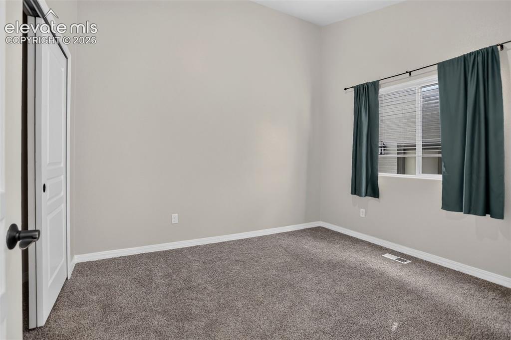 Image 27 of 50: Carpeted flooring, neutral wall paint, and a window with blinds