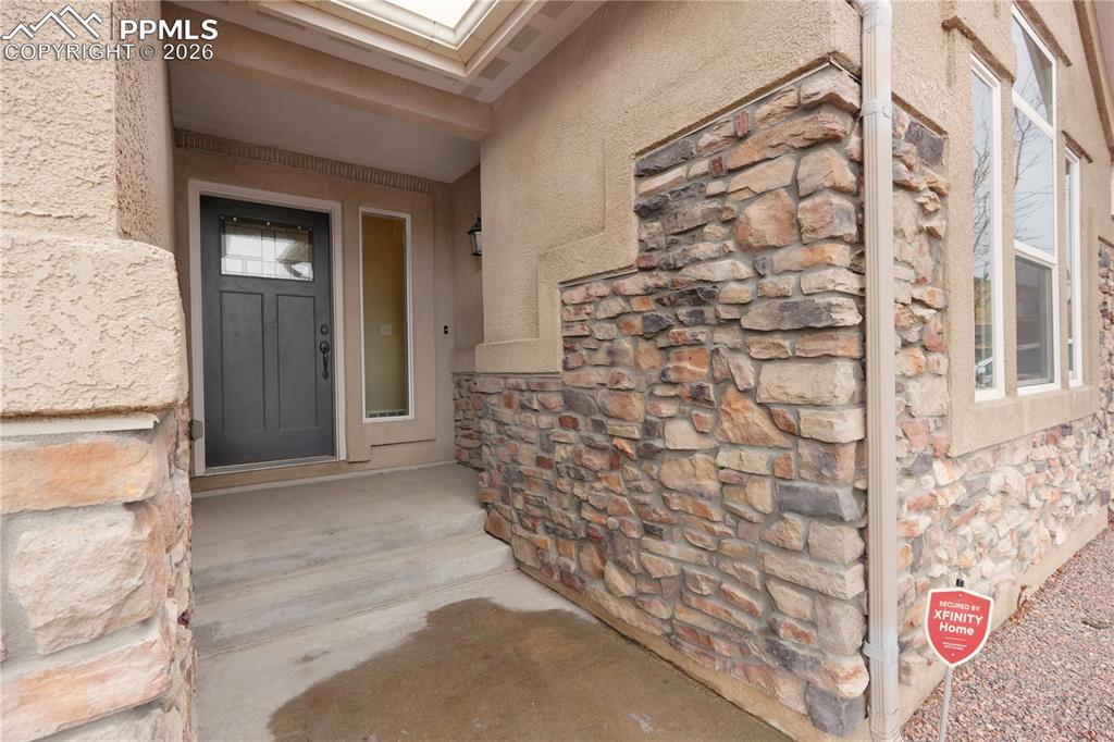Image 3 of 44: Entrance to property featuring stone siding and stucco siding
