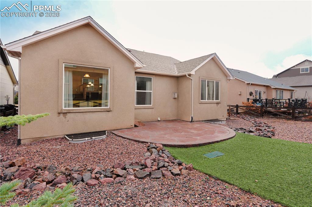 Image 40 of 44: Rear view of house with a patio, stucco siding, roof with shingles, and a d