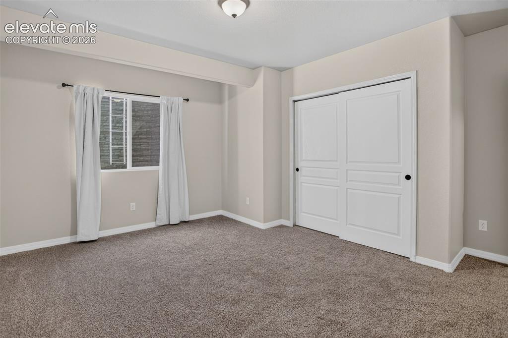 Image 40 of 50: Recessed lighting, neutral wall paint, textured carpet flooring, and a wind