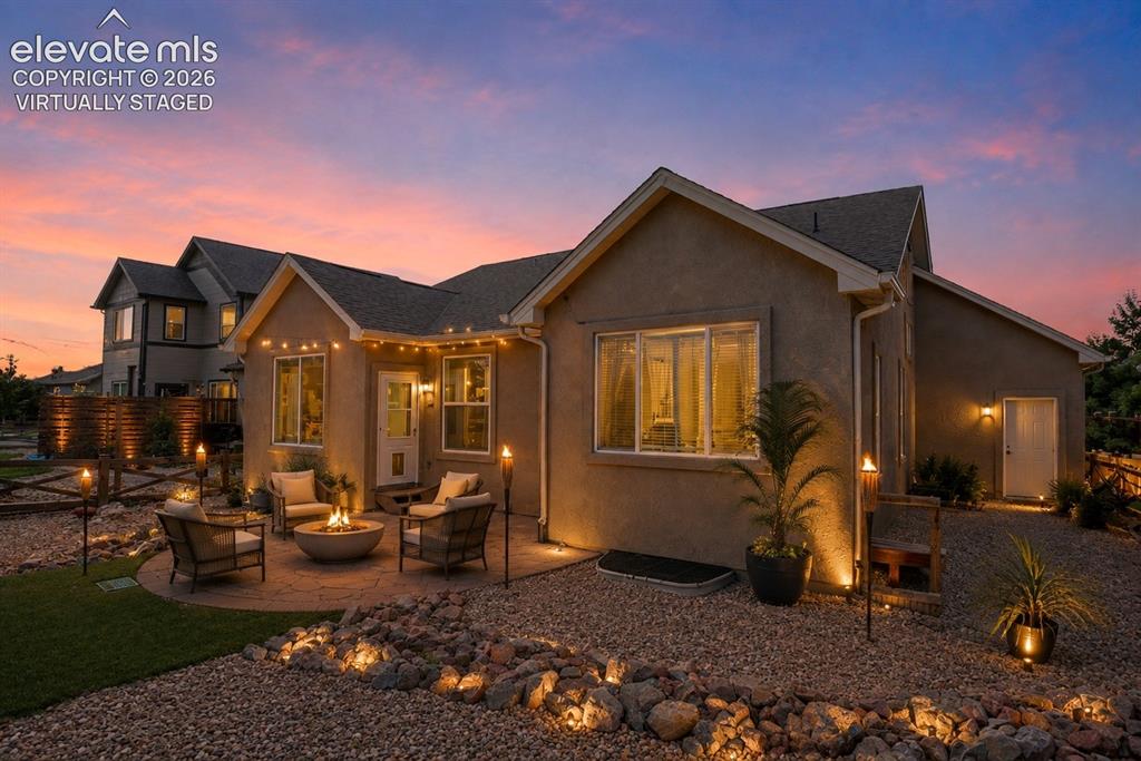 Image 47 of 50: Virtually Staged - Stucco exterior with a paver patio, a built-in fire pit,