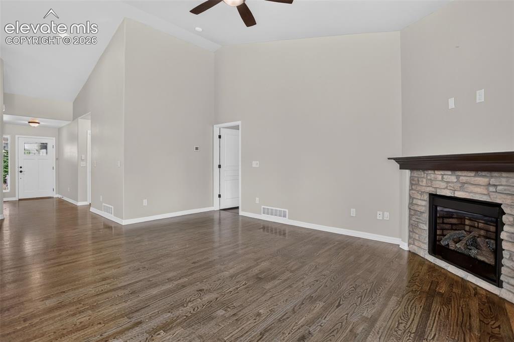 Image 5 of 50: Spacious interior with high vaulted ceilings, rich wood-finish flooring, an
