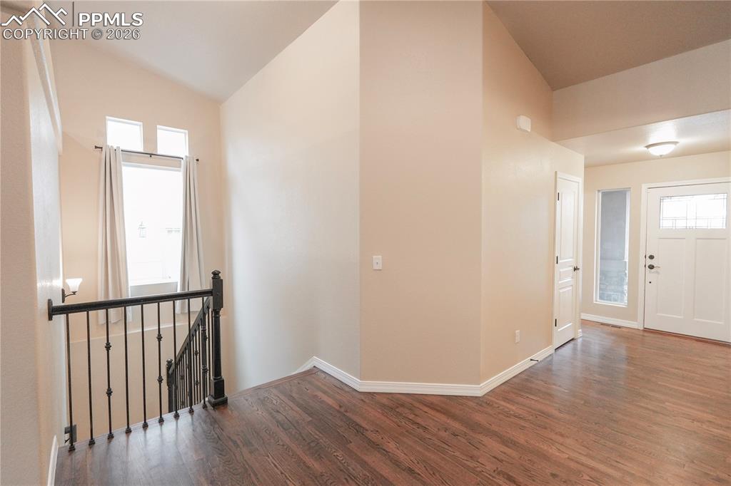 Image 6 of 44: Foyer entrance featuring vaulted ceiling and dark wood finished floors