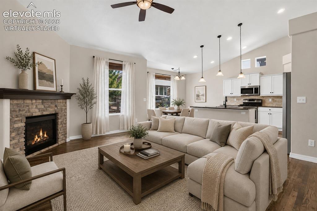 Image 6 of 50: Virtually Staged - Wood-finish flooring, stone-surround fireplace with a da