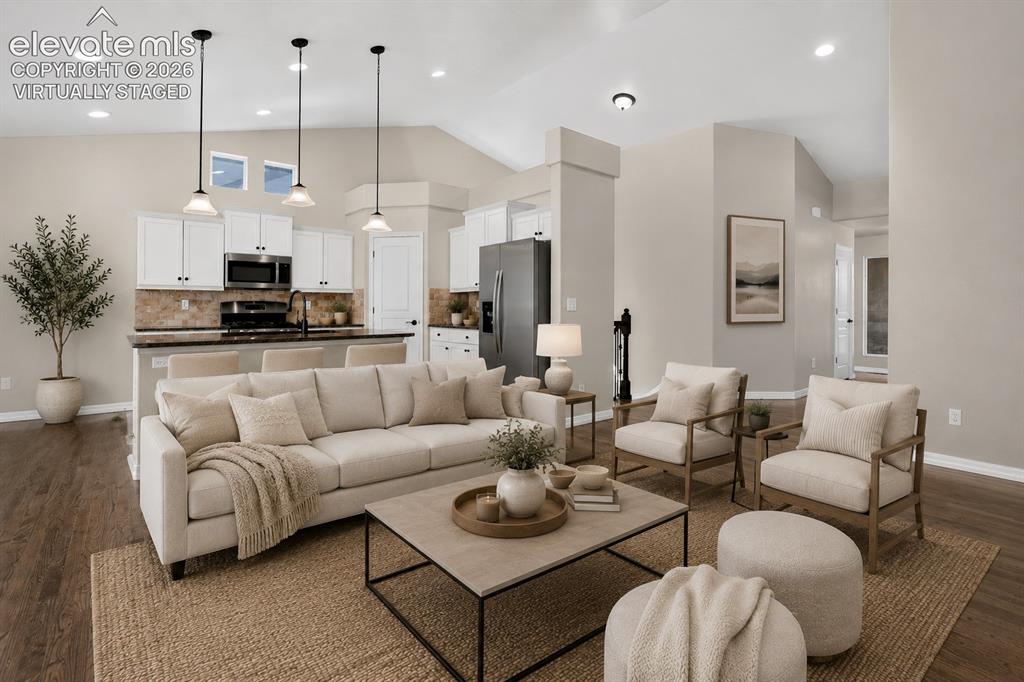Image 9 of 50: Virtually Staged - Open-concept living space featuring vaulted ceilings, wo