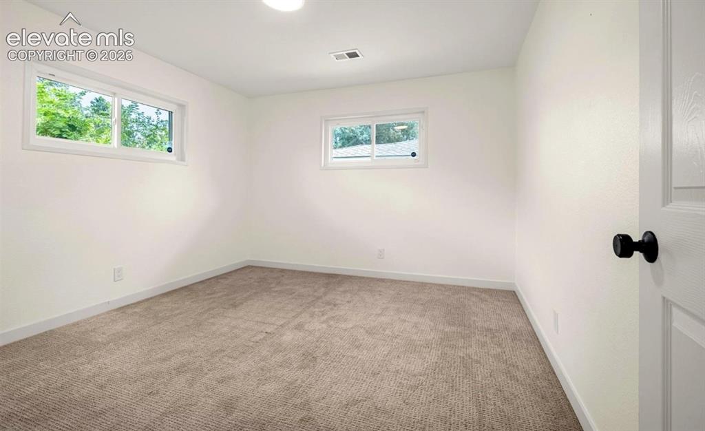 Image 8 of 11: Neutral wall color with two windows, recessed ceiling lighting, and carpet 