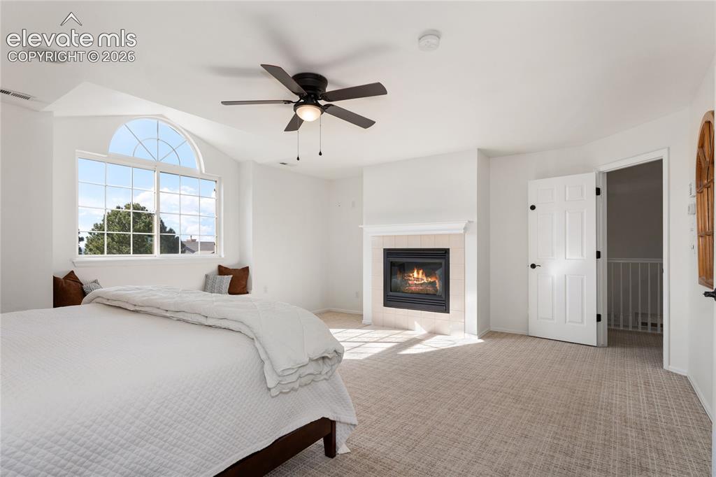 Image 24 of 42: primary bedroom features a gas fireplace
