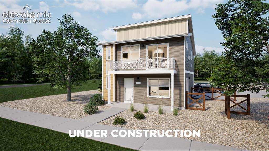 Caption: Modern two-story residence with a balcony featuring white railings, a concrete walkway, and a gravel