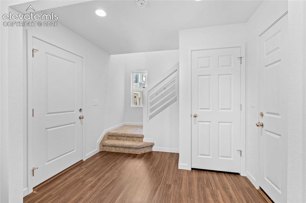 Image 4 of 25: Wood-finish flooring, recessed lighting, white interior doors, carpeted sta