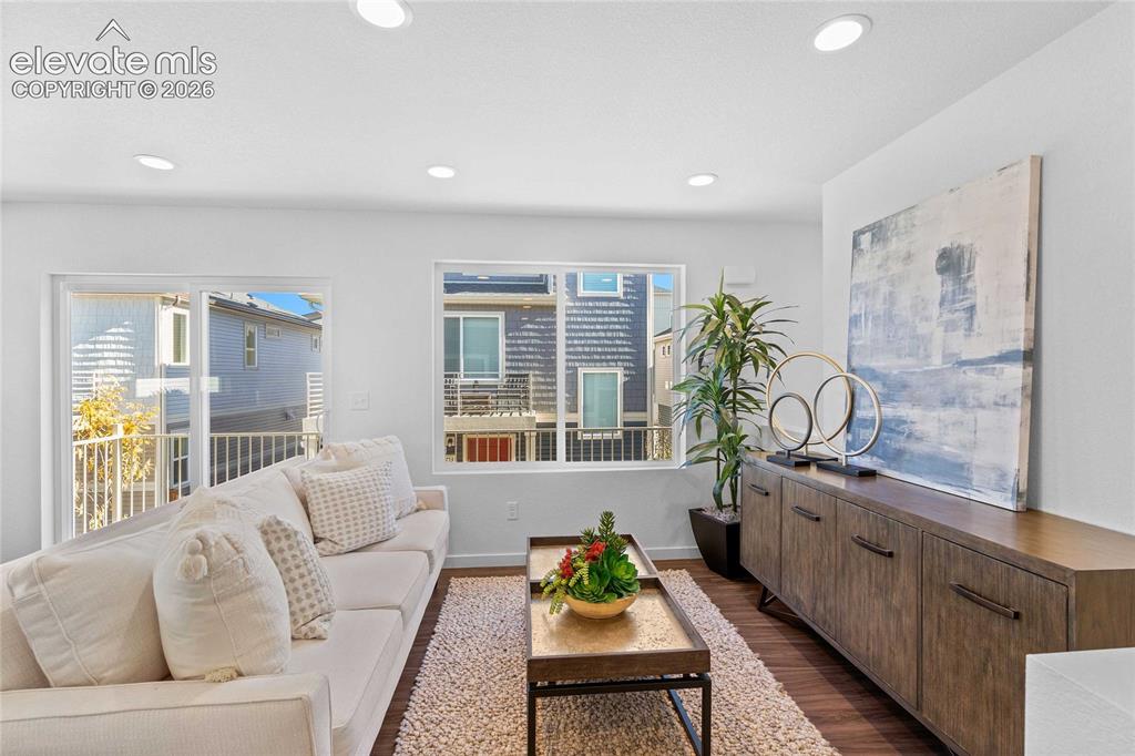 Image 8 of 25: Recessed lighting, wood-finish flooring, white walls, built-in credenza, an