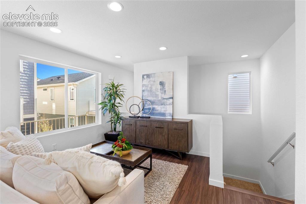 Image 9 of 25: Recessed ceiling lighting illuminates a spacious room featuring wood-finish
