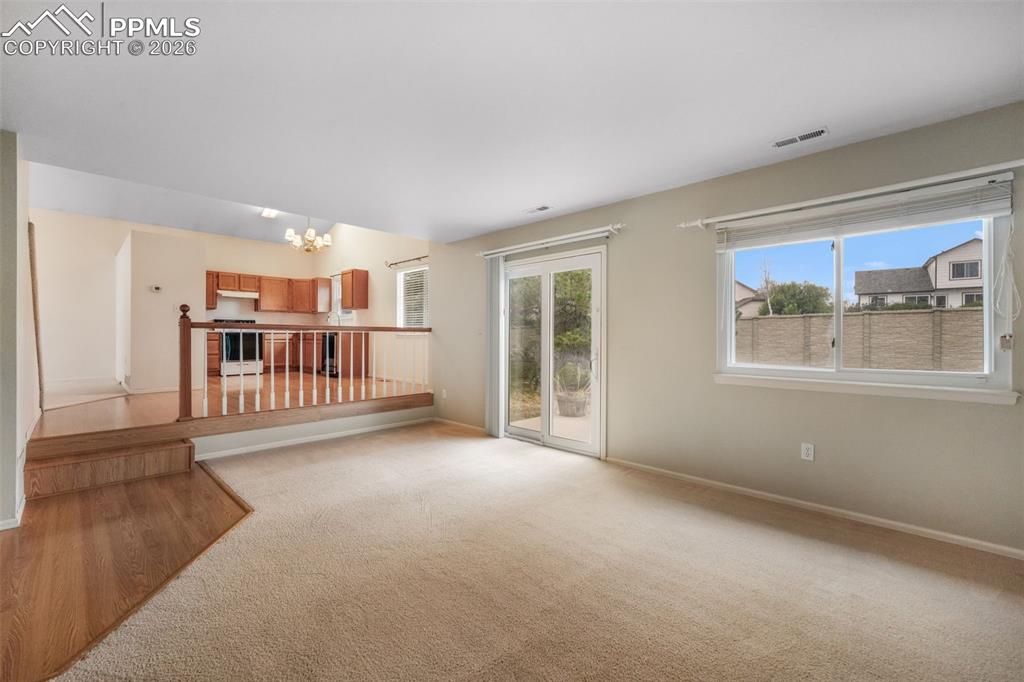 Image 19 of 45: Living area featuring a corner fireplace with a white mantel, a ceiling fan