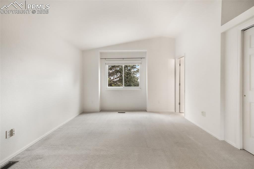 Image 22 of 45: Carpeted living area featuring a fireplace with a tiled surround, a ceiling