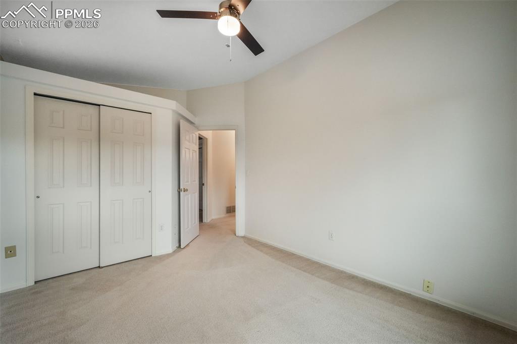 Image 26 of 45: Bright room featuring a window with exterior tree coverage, neutral-toned c