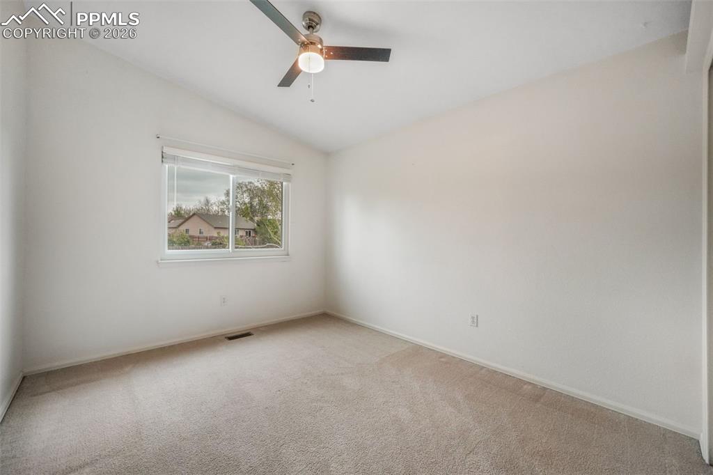 Image 28 of 45: Light-filled room featuring neutral carpeting, a large sliding panel closet