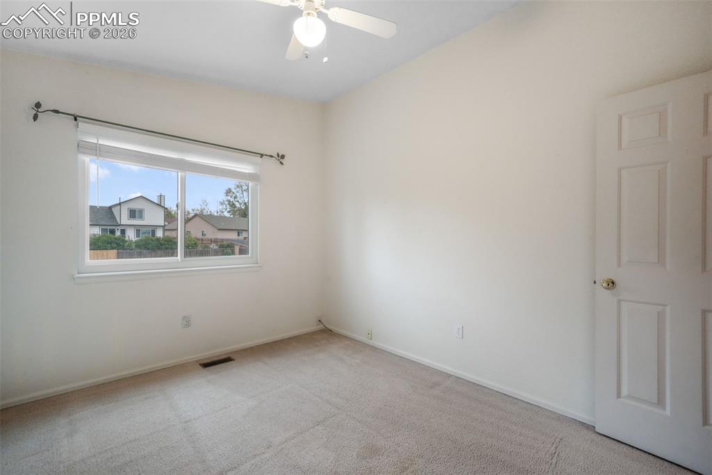 Image 29 of 45: Carpeted room featuring a vaulted ceiling and a ceiling fan