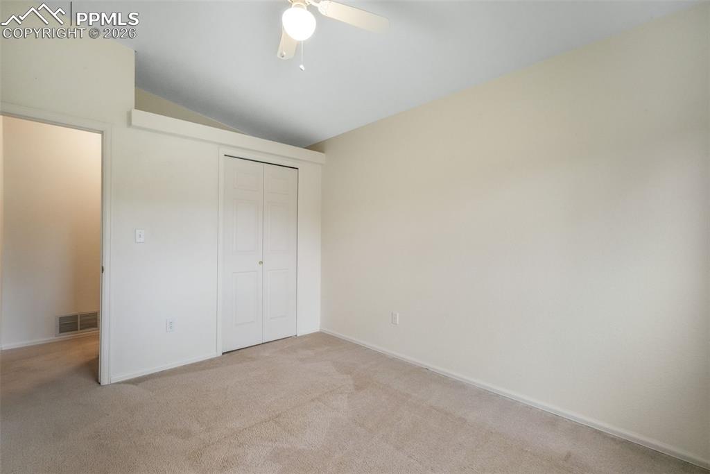 Image 31 of 45: Carpeted room with a large window, a ceiling fan, and white walls