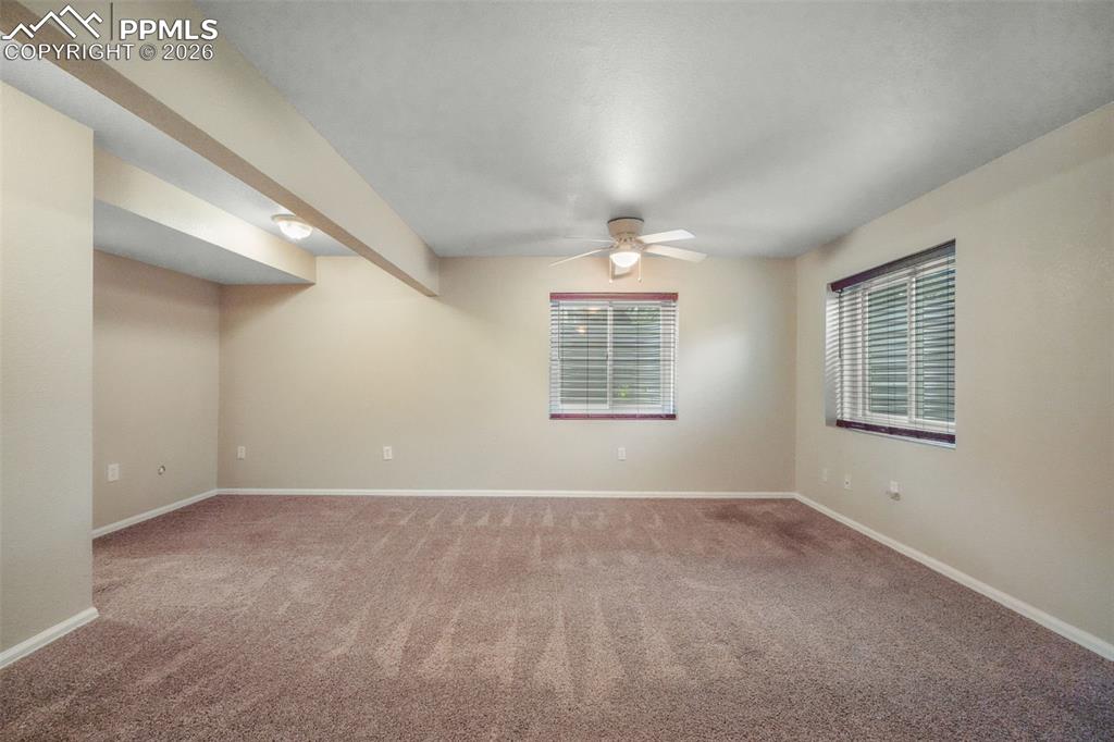 Image 34 of 45: Carpeted interior space featuring a vaulted ceiling and a ceiling fan with 