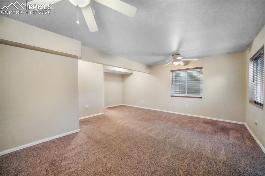Image 35 of 45: Carpeted interior space featuring a ceiling fan with integrated lighting, b