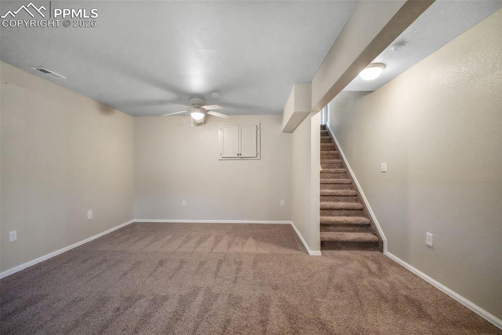 Image 38 of 45: Spacious room featuring neutral carpeting, light beige walls, two windows w