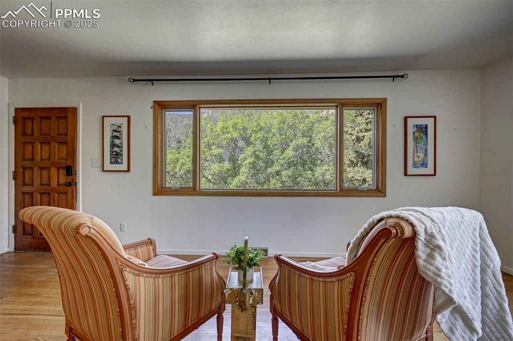 Image 10 of 50: An oversized wood-framed window showcases the surrounding trees & peaks.