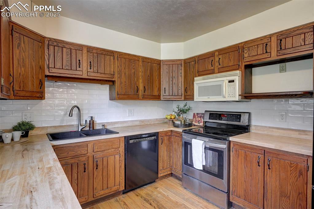 Image 18 of 50: The Kitchen blends classic & contemporary with wood cabinets, butcher block