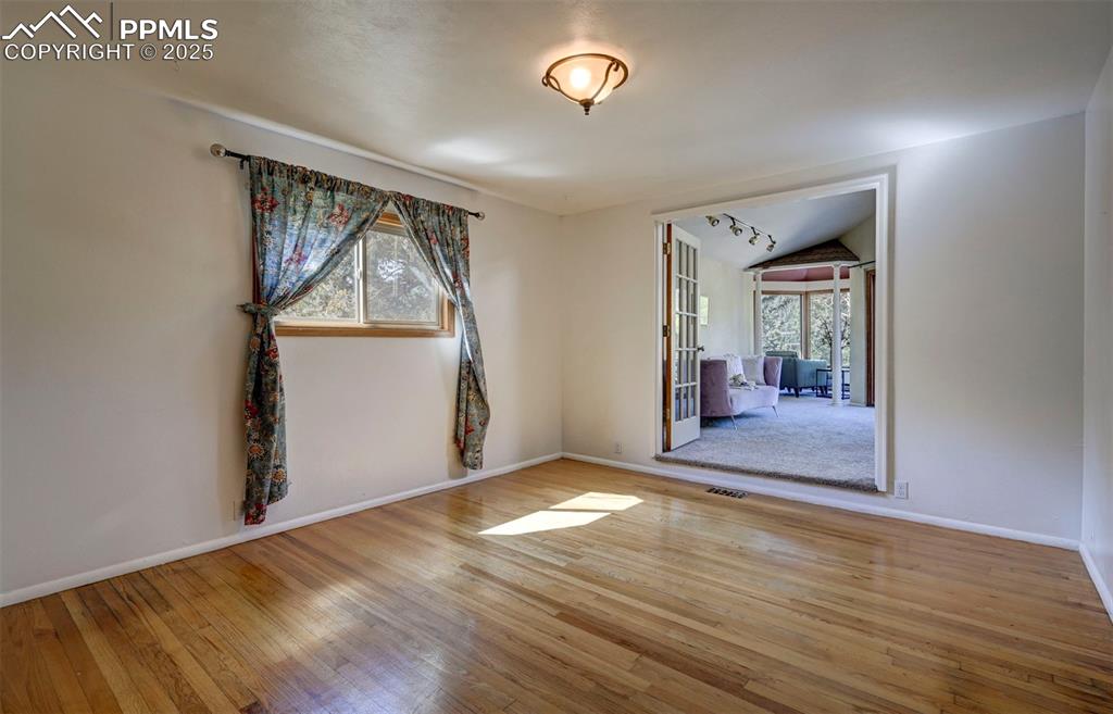 Image 23 of 50: The main level Primary Bedroom is a true sanctuary with French doors into
