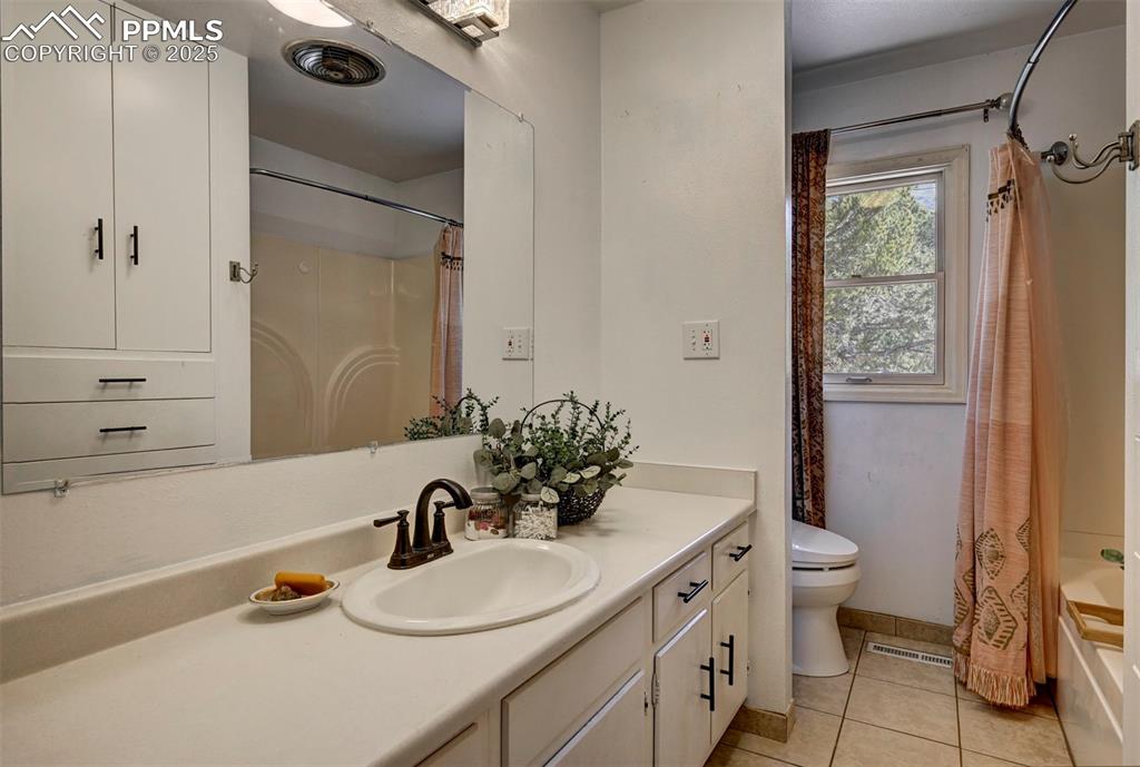 Image 33 of 50: Full Main Level Bathroom with a tile floor, extended vanity, built in stora