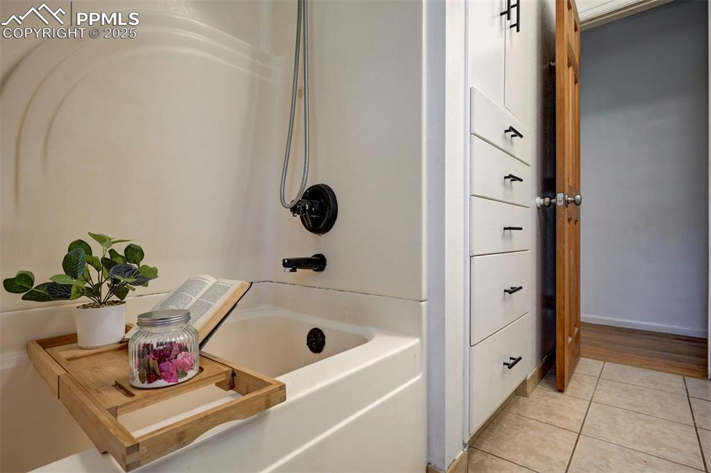 Image 34 of 50: Tub/Shower and built-in storage in the Main Level Bathroom.