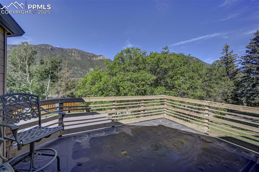 Image 7 of 50: Front yard deck overlooking beautiful trees and mountains.