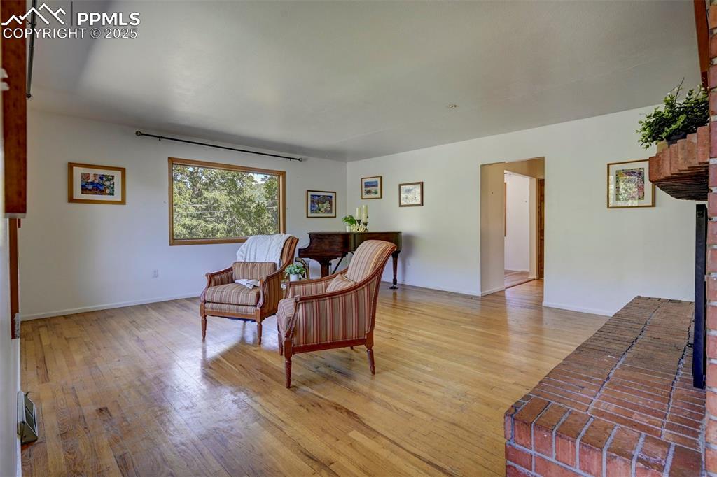 Image 8 of 50: The spacious Living Room is defined by oversized wood framed windows and a