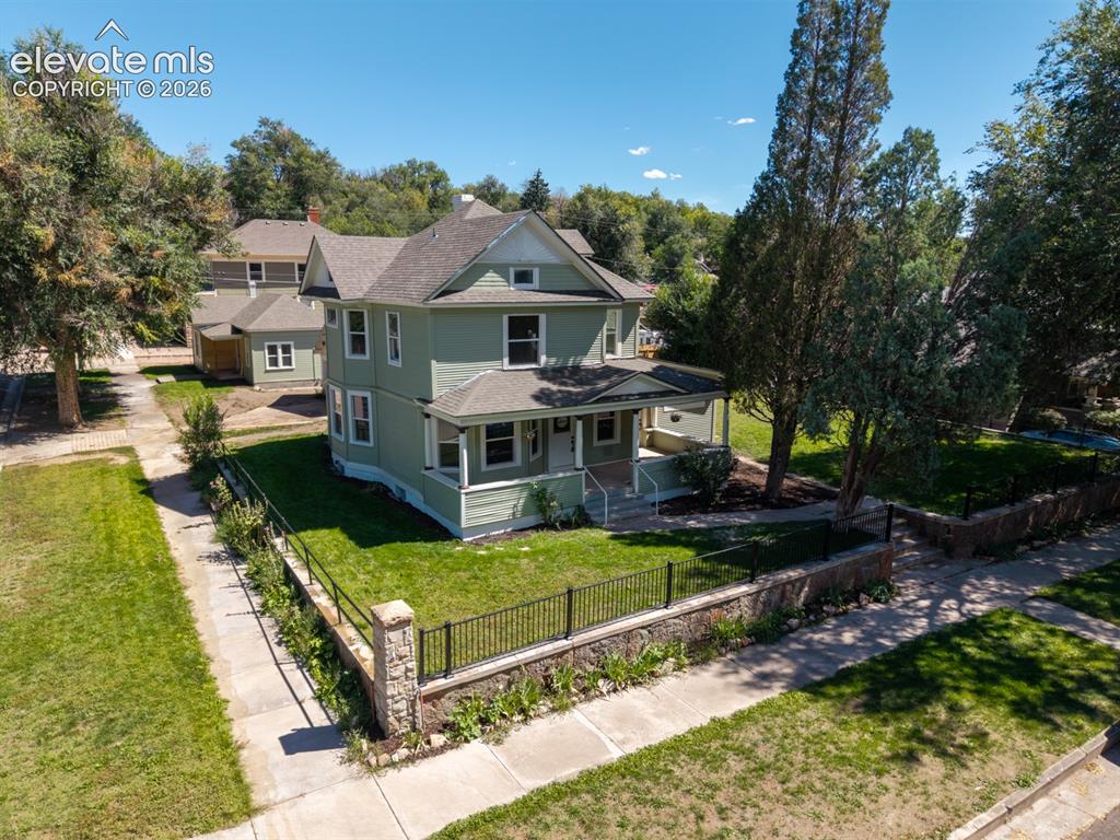 Caption: Two-story property with a light green exterior, gabled roof, and multiple windows