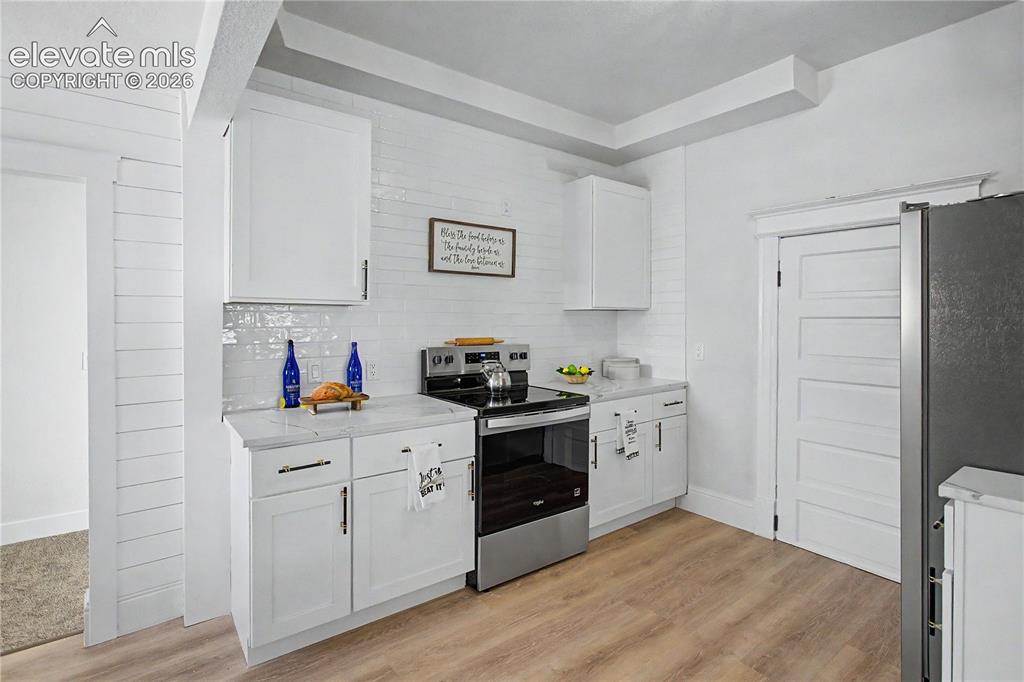 Image 13 of 35: White upper and lower cabinetry, stainless steel oven with an electric cook