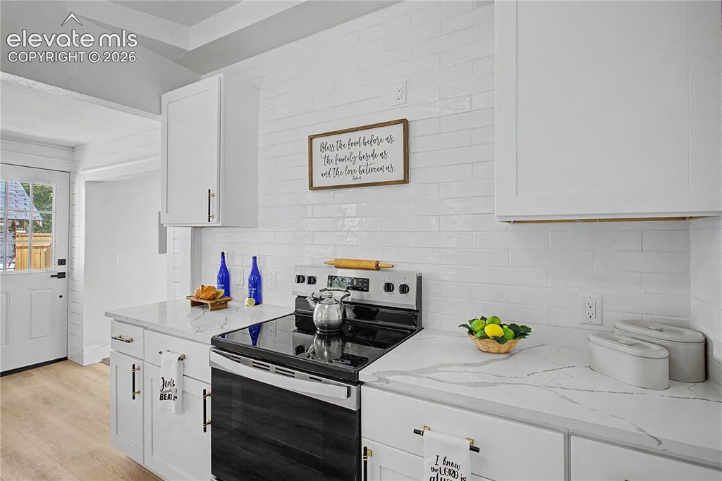 Image 14 of 35: White cabinetry, white subway tile backsplash, white countertops, built-in