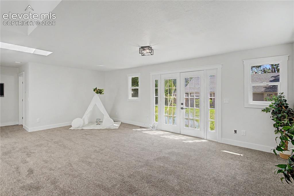 Image 19 of 35: White-painted walls with recessed lighting, skylight, and wall-to-wall carp