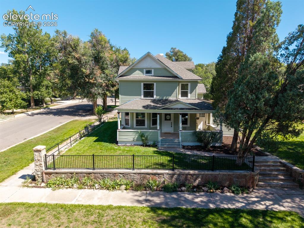 Image 2 of 35: Two-story residence with a covered front porch and a gabled roof
