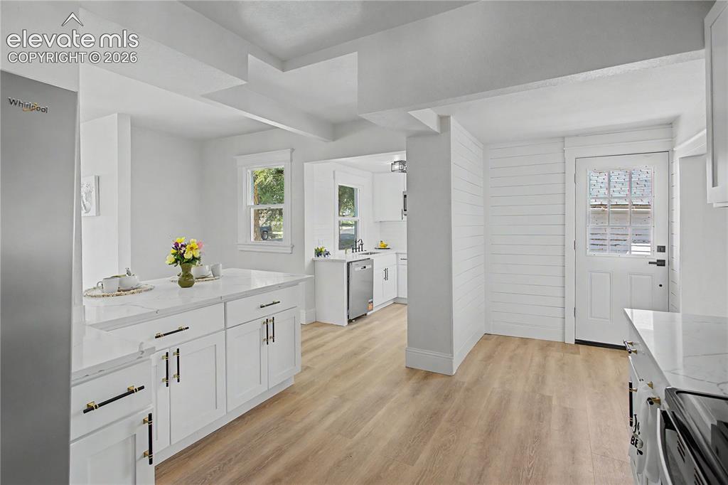 Image 21 of 35: White shaker-style cabinetry with gold-tone and black hardware