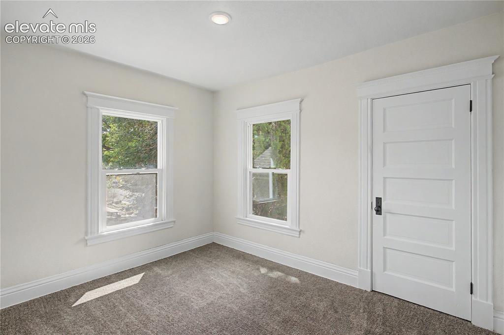 Image 22 of 35: Recessed ceiling lighting, two double-hung windows, panel door with dark ha