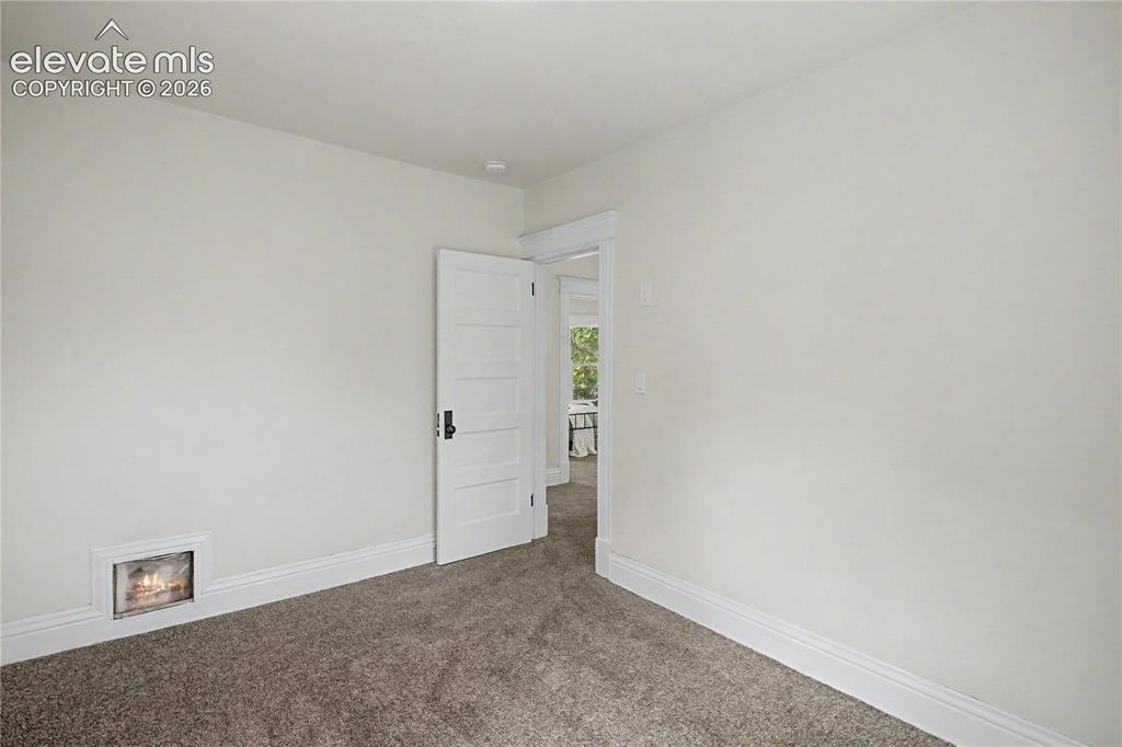 Image 23 of 35: Plush carpeting, white wall paint, classic door trim, paneled interior door