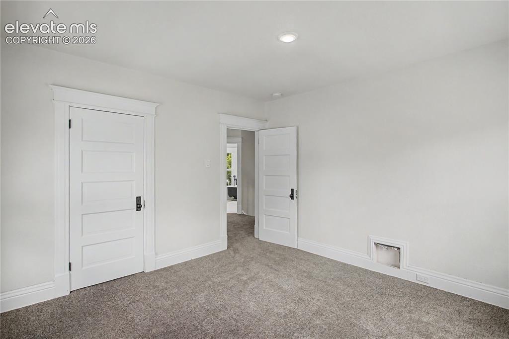 Image 25 of 35: Recessed ceiling lighting, paneled doors with dark hardware, wide baseboard