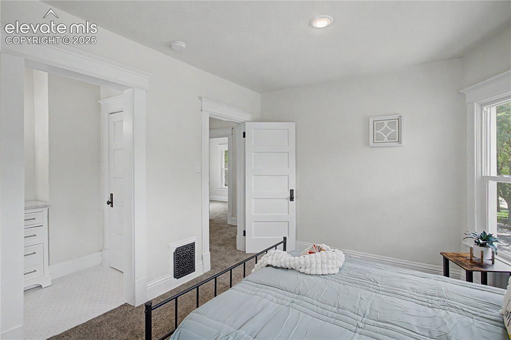 Image 27 of 35: Recessed ceiling lighting, white five-panel interior door, built-in dresser