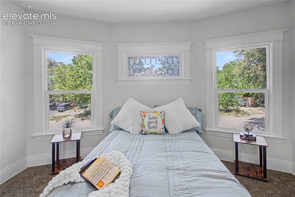 Image 29 of 35: Bay window with three distinct window units, decorative stained glass trans