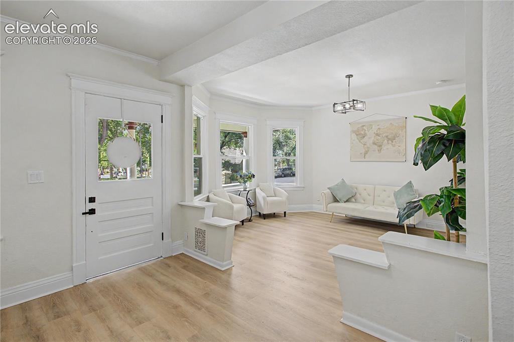 Image 4 of 35: Entryway with wood-finish flooring, a white paneled door with glass inserts