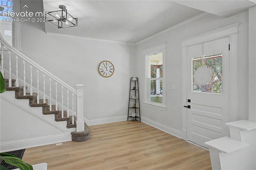 Image 8 of 35: Entryway featuring wood-finish flooring, a white paneled entry door with si