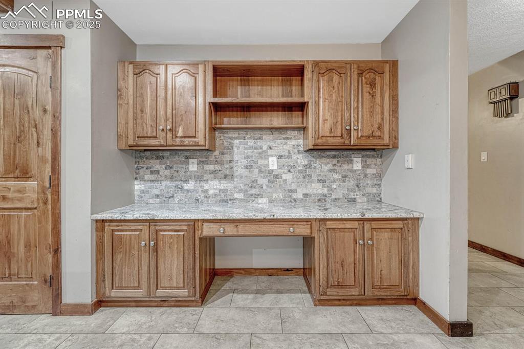 Image 13 of 47: Unfurnished office with built in study area and baseboards